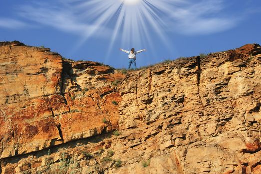 The woman at top of a rock in beams of the sun (symbolizing freedom)