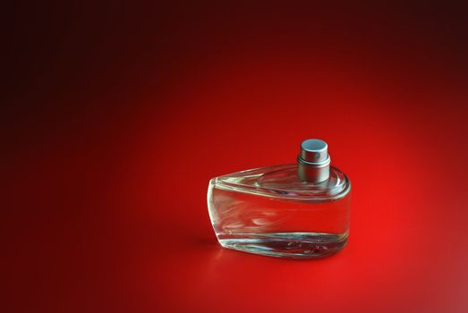 perfume. A bottle perfume on a red background with effective illumination