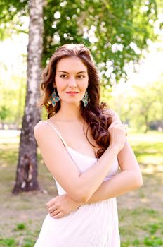 Portrait of an attractive woman in the park, crossed her arms