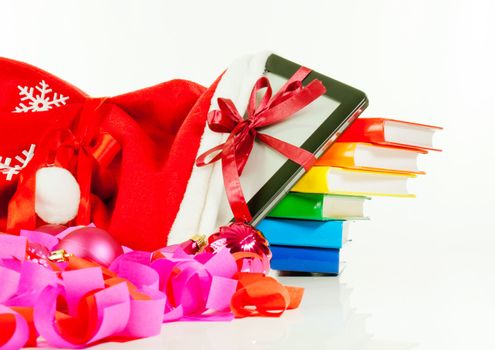 Electronic book reader with stack of books in bag against white background