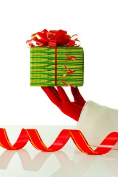 Santa's hand holding a Christmas present against white background