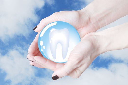 hands holding tooth in glass sphere, dentistry  