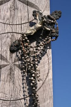 Rosaries and small cross in the background of wooden decoration