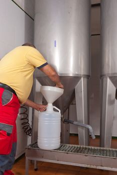 Farmer collecting the freshly pressed oil from his olive crop