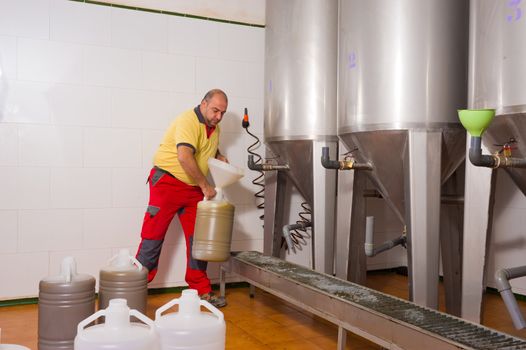 Farmer collecting the freshly pressed oil from his olive crop