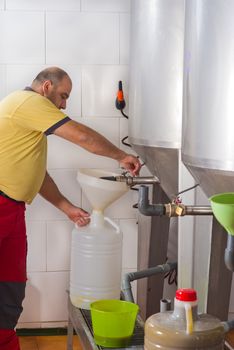 Farmer collecting the freshly pressed oil from his olive crop