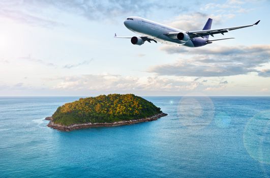 A passenger plane flies over tropical island