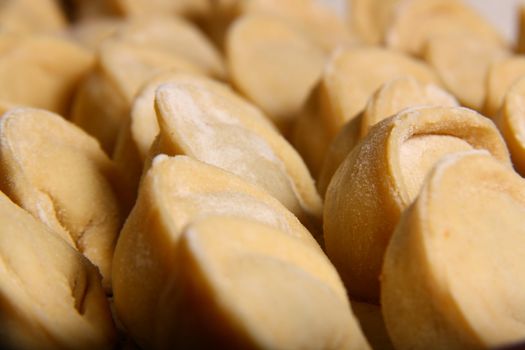 hand made ravioli getting prepared on table waiting for cooking