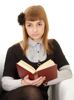 A young woman reads a book on white