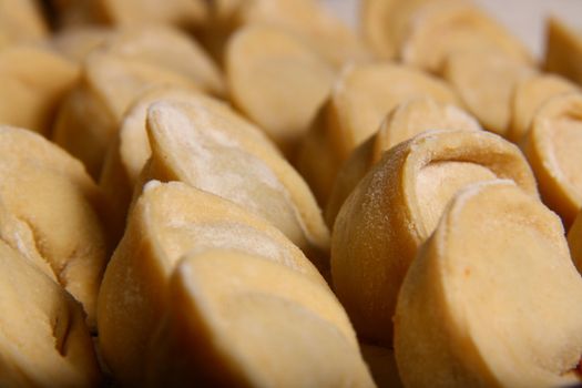 hand made ravioli getting prepared on table waiting for cooking