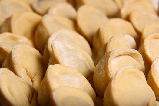 hand made ravioli getting prepared on table waiting for cooking