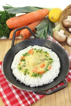 a pan with rice and colorful chicken fricassee