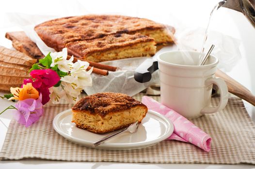 A sheet cake with cinnamon sugar butter and a hot cup of coffee