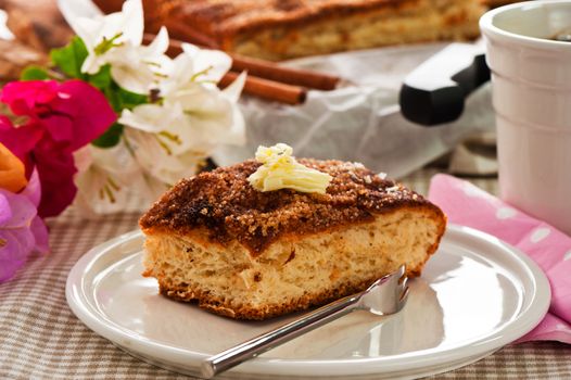 A sheet cake with cinnamon sugar butter and a hot cup of coffee