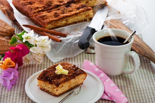 A sheet cake with cinnamon sugar butter and a hot cup of coffee