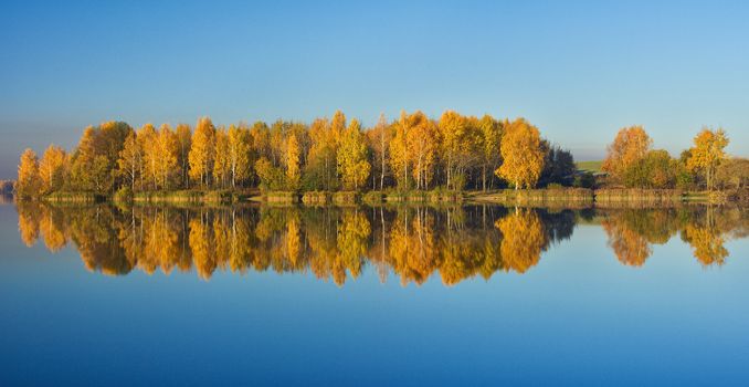 autumn trees with reflection in water, panorama 