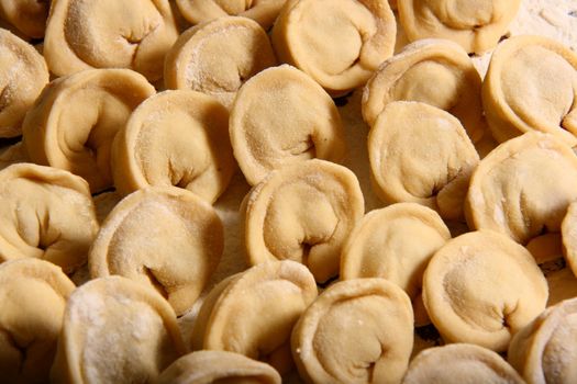 hand made ravioli getting prepared on table waiting for cooking