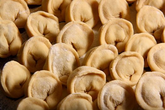 hand made ravioli getting prepared on table waiting for cooking