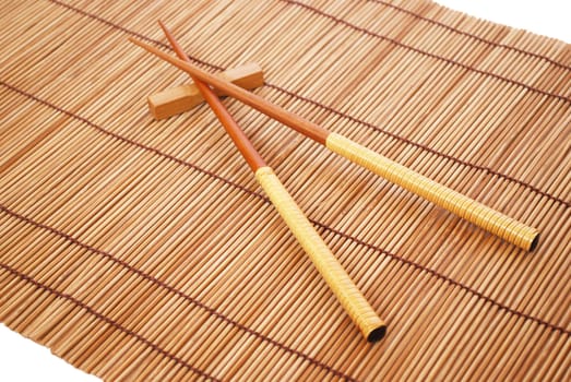 Chopsticks on brown bamboo matting background 