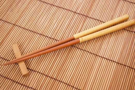 Chopsticks on brown bamboo matting background 