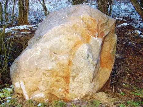 a big stone ist standing behind the lakefront.