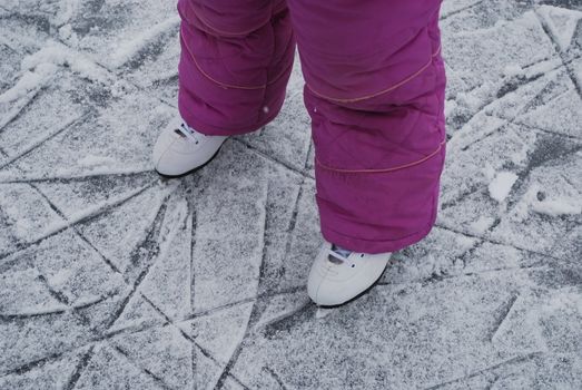 child  foots with skates on ice