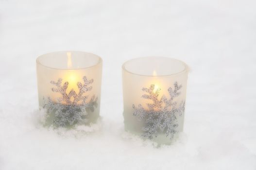 Two white candlelights in the snow