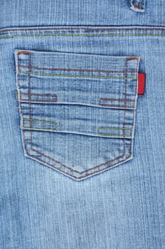Rear blue denim jeans pocket with colourful stitches.