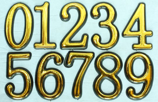 Golden bright numbers on a light blue background. Numbers 0, 1, 2, 3, 4, 5, 6, 7, 8 and 9.