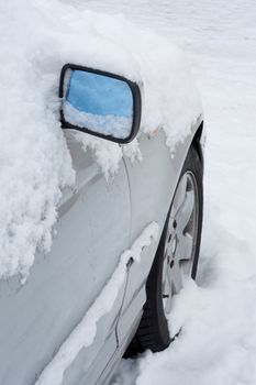 Closeup of a car covered in snow.
