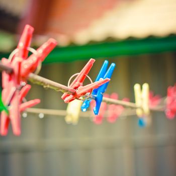 Colorful clothes pegs hanging in the line wire
