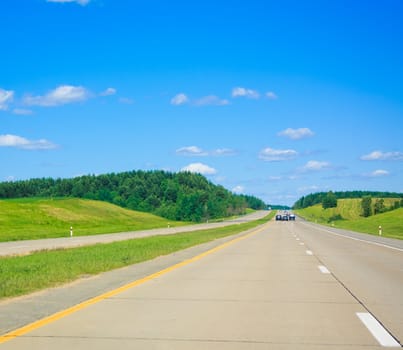 Long road in front of blue sky and mountains