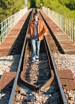 Musician with his guitar on top of a railway bridge
