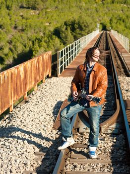 Guitarist performing on a railway bridge