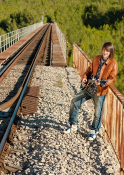 Guitarist performing on a railway bridge