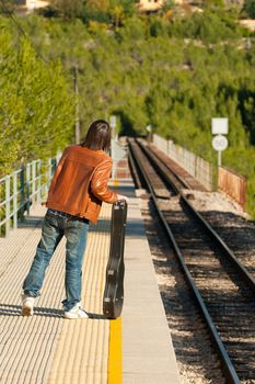 Commuter with a guitar waiting for the train