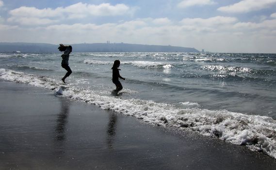 children jumping on the beach