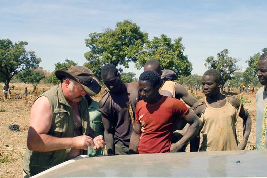 At the goldmine of Poura a French arrived and seeks to buy gold nuggets at the best price. Discussed are sharp and the cap of the car serves as office. The minors encircles the white man.                               
