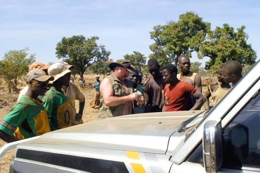 At the goldmine of Poura a French arrived and seeks to buy gold nuggets at the best price. Discussed are sharp and the cap of the car serves as office. The minors encircles the white man.                               
