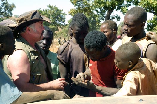 At the goldmine of Poura a French arrived and seeks to buy gold nuggets at the best price. Discussed are sharp and the cap of the car serves as office. The minors encircles the white man.                               
