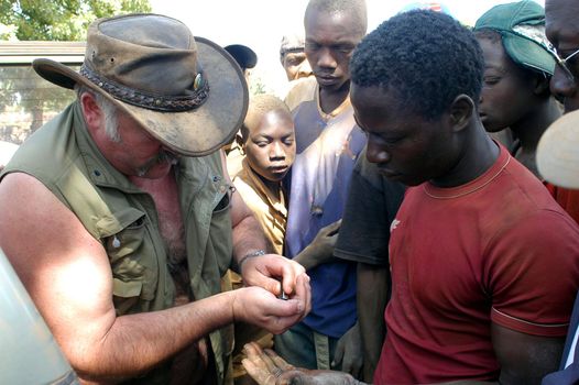 At the goldmine of Poura a French arrived and seeks to buy gold nuggets at the best price. Discussed are sharp and the cap of the car serves as office. The minors encircles the white man.                               