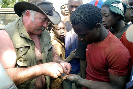 At the goldmine of Poura a French arrived and seeks to buy gold nuggets at the best price. Discussed are sharp and the cap of the car serves as office. The minors encircles the white man.                               