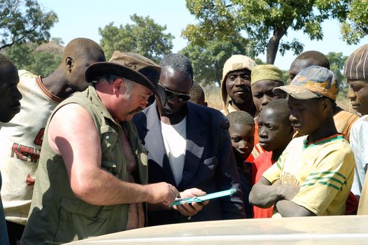 At the goldmine of Poura a French arrived and seeks to buy gold nuggets at the best price. Discussed are sharp and the cap of the car serves as office. The minors encircles the white man.                               
