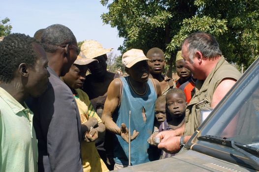 At the goldmine of Poura a French arrived and seeks to buy gold nuggets at the best price. Discussed are sharp and the cap of the car serves as office. The minors encircles the white man.                               