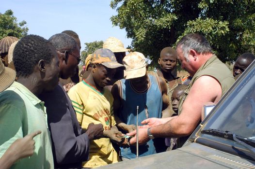 At the goldmine of Poura a French arrived and seeks to buy gold nuggets at the best price. Discussed are sharp and the cap of the car serves as office. The minors encircles the white man.                               