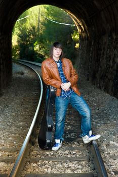 Cool guitarist portrayed inside a railway tunnel