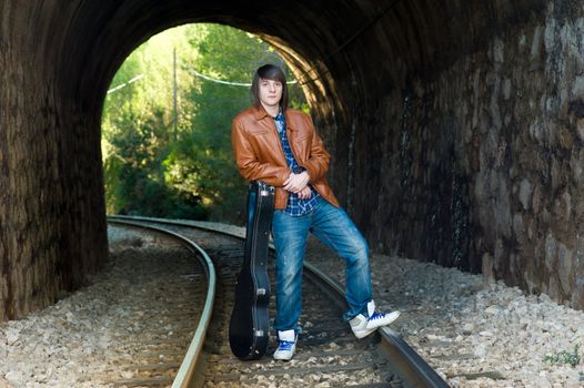 Cool guitarist portrayed inside a railway tunnel