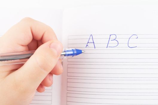 Child's hand wrote the first letter in the notebook