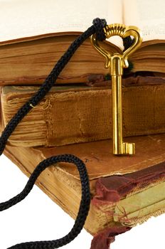 Golden key on old books isolated on white background