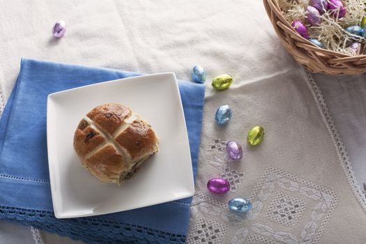 Hot cross bun from above with chocolate easter eggs